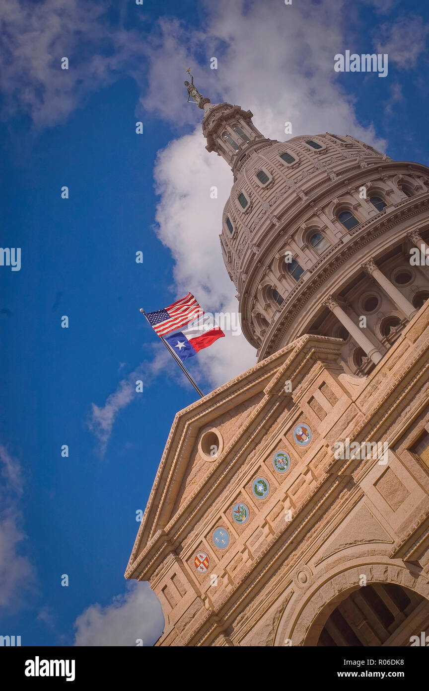 American e Texas bandiere sopra il Texas Capitol Building di Austin, Texas, Stati Uniti d'America. Sopra la porta di ingresso sono simboli (guarnizioni) per Six Flags che hanno volato oltre il membro (Spagna, Messico, Francia, Repubblica del Texas, Stati Confederati e gli Stati Uniti. Foto Stock