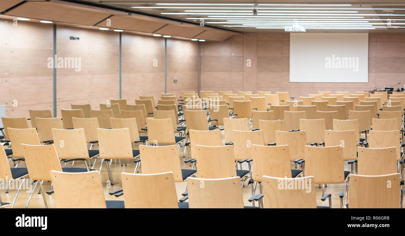 Svuotare posti a sedere in legno in un cotmporary aula magna. Foto Stock