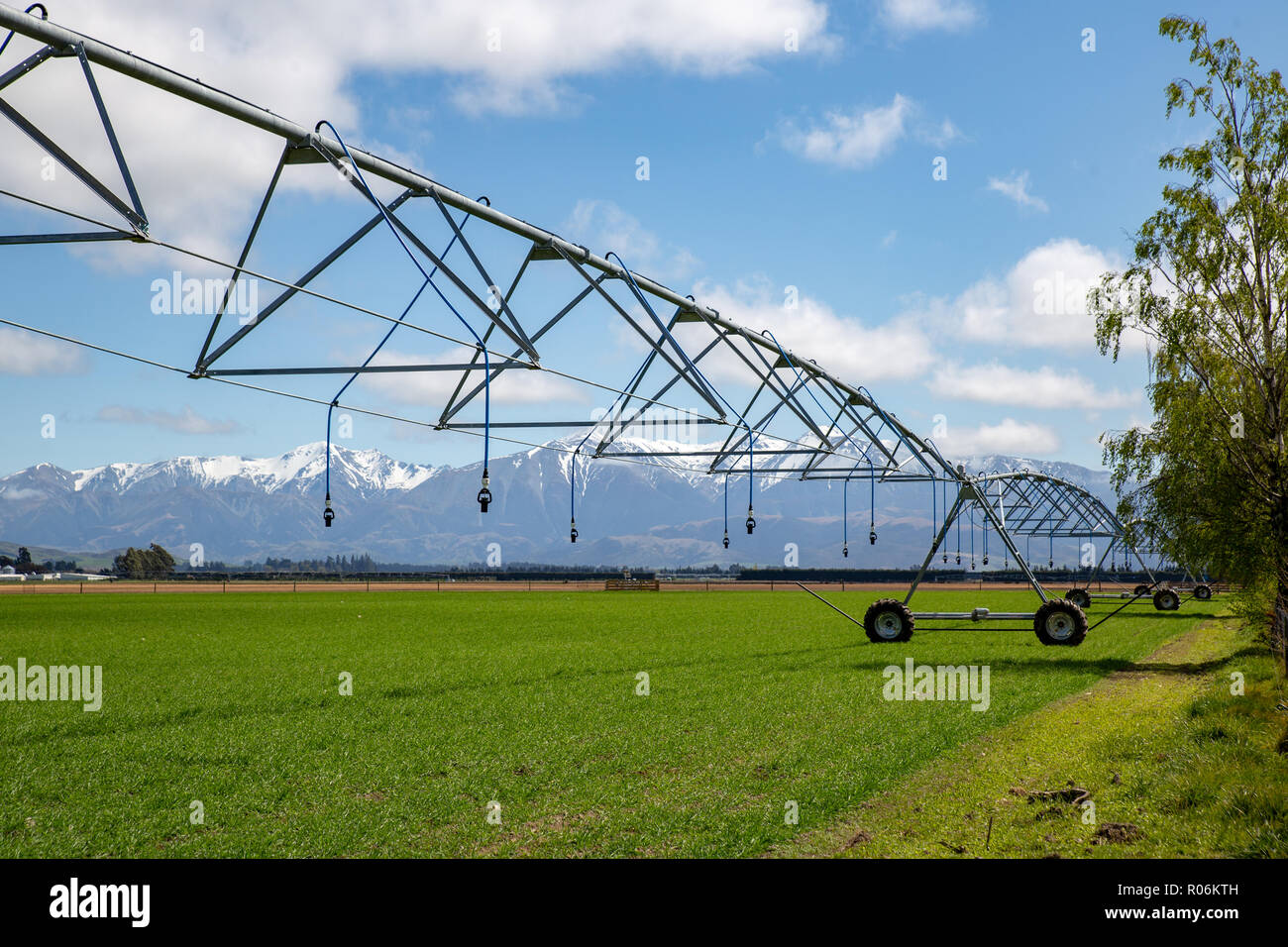 Un perno centrale irrigatore impostato su una fattoria rurale in un grande campo pronto per irrigare le colture in primavera in Nuova Zelanda Foto Stock Un perno centrale irrigatore impostato su una fattoria rurale in un grande campo pronto per irrigare le colture in primavera in Nuova Zelanda Foto Stock