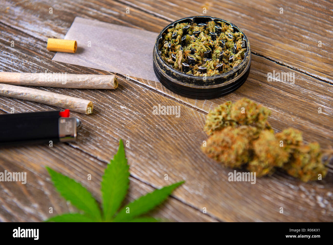 La Cannabis giunti con carta di laminazione e macinare su uno sfondo di legno Foto Stock