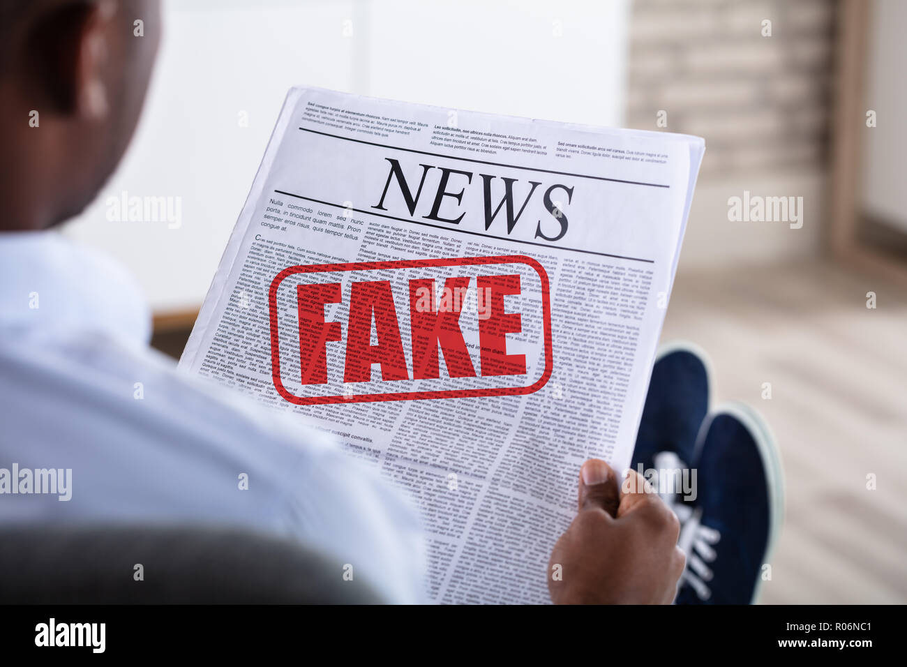 Close-up di un uomo africano azienda giornale con finti News Foto Stock