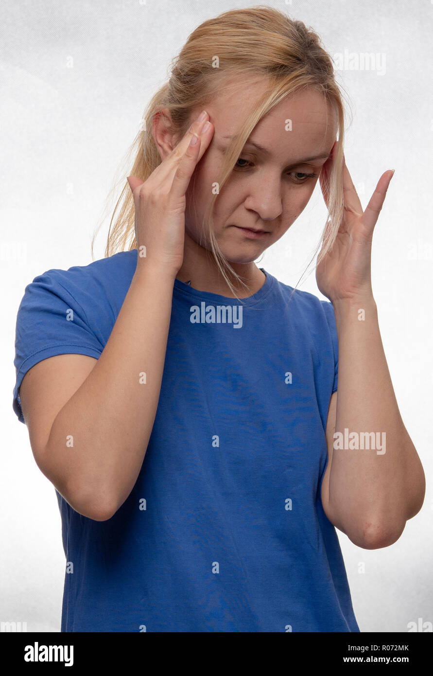 Donna informale in maglietta blu con il mal di testa Foto Stock