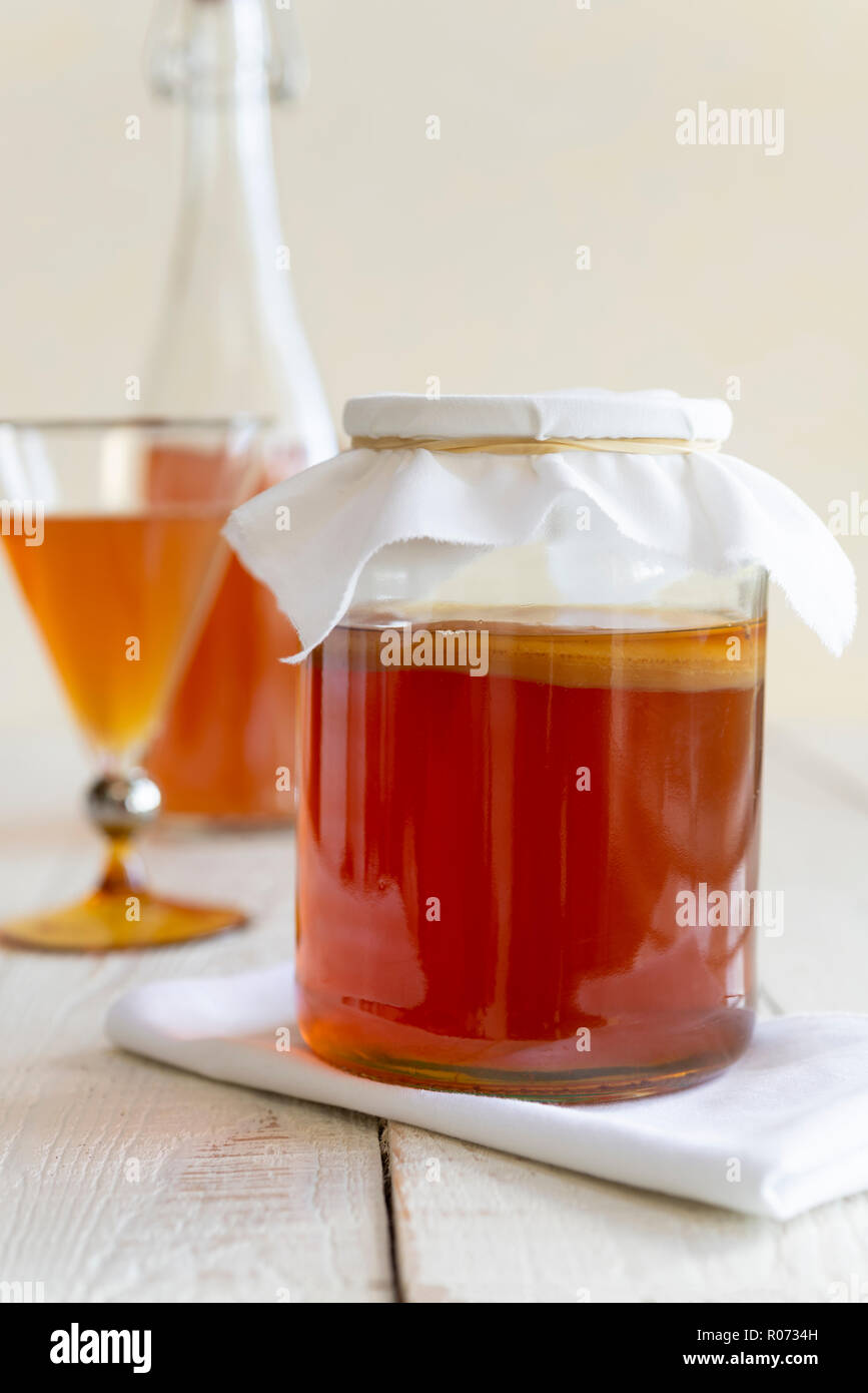 Fare in casa il Kombucha - fermentazione di tè in un vasetto di vetro con un SCOBY. Foto Stock
