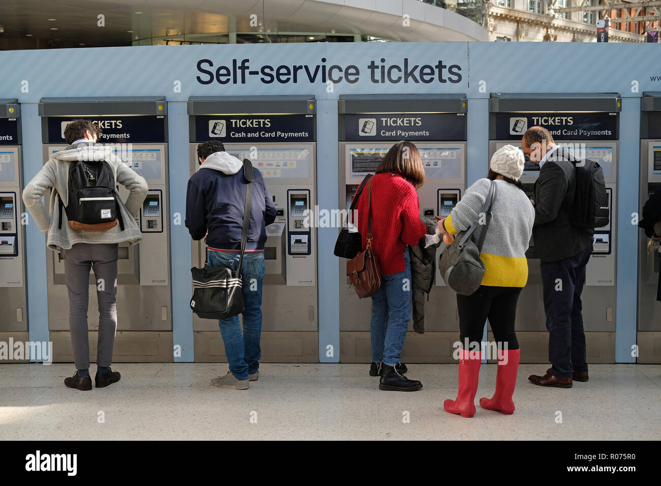 Le persone che usano il self-service ticket machine presso la stazione di Waterloo, Londra. Foto Stock