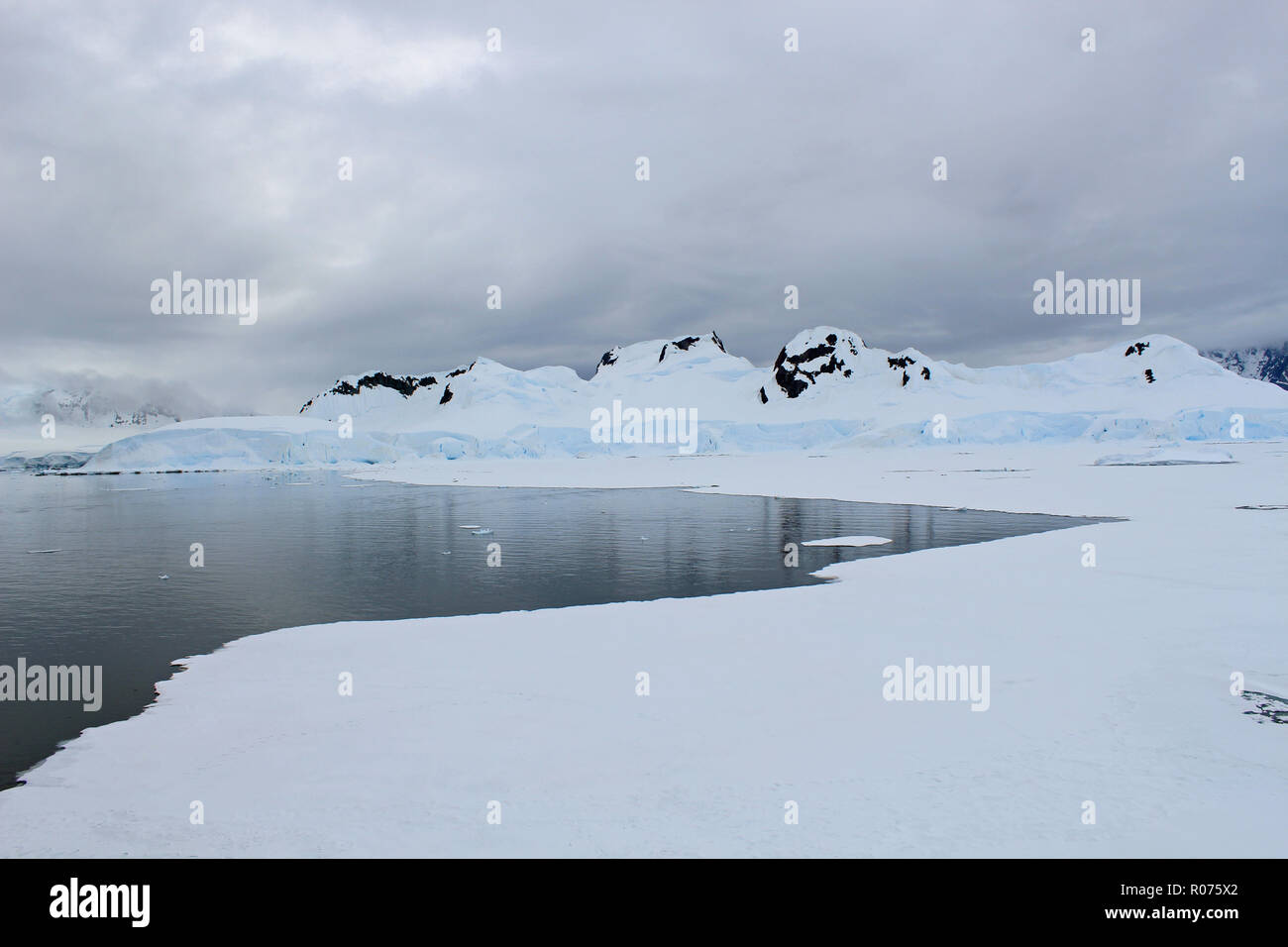 Il selvaggio e spietato paesaggio dell'Antartide. Questa penisola antartica vista iceflows, cime coperte di neve e scintillanti acque congelate Foto Stock
