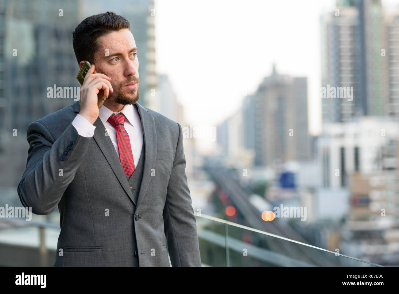 Bel giovane imprenditore caucasico parlando al telefono mobile a Foto Stock