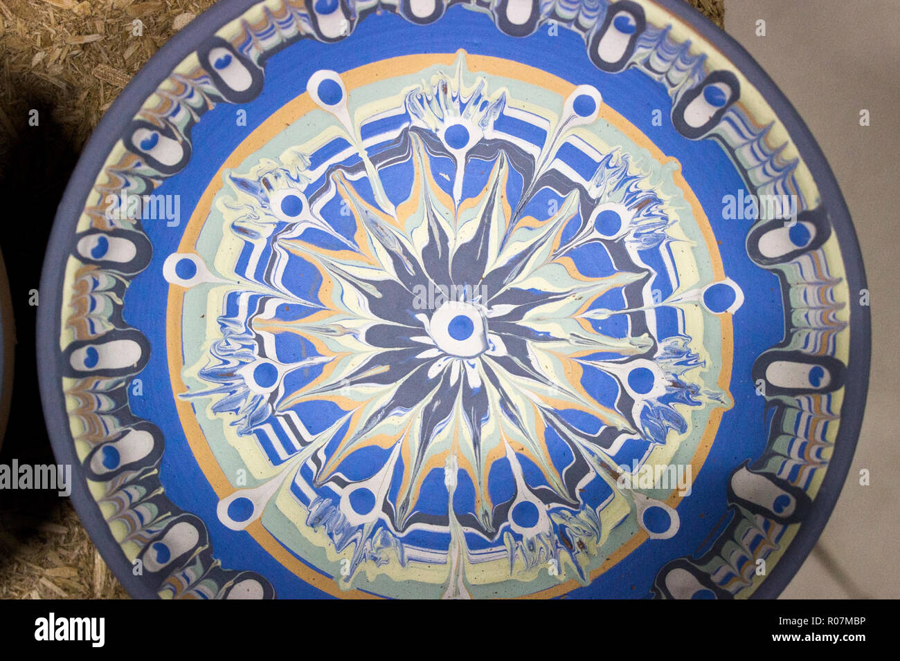 Vasellame dipinto con engobbio è un misto di slittamento con multi-pigmenti colorati su un appartamento in ceramica con la partecipazione di un artigiano bulgaro con 1 Foto Stock