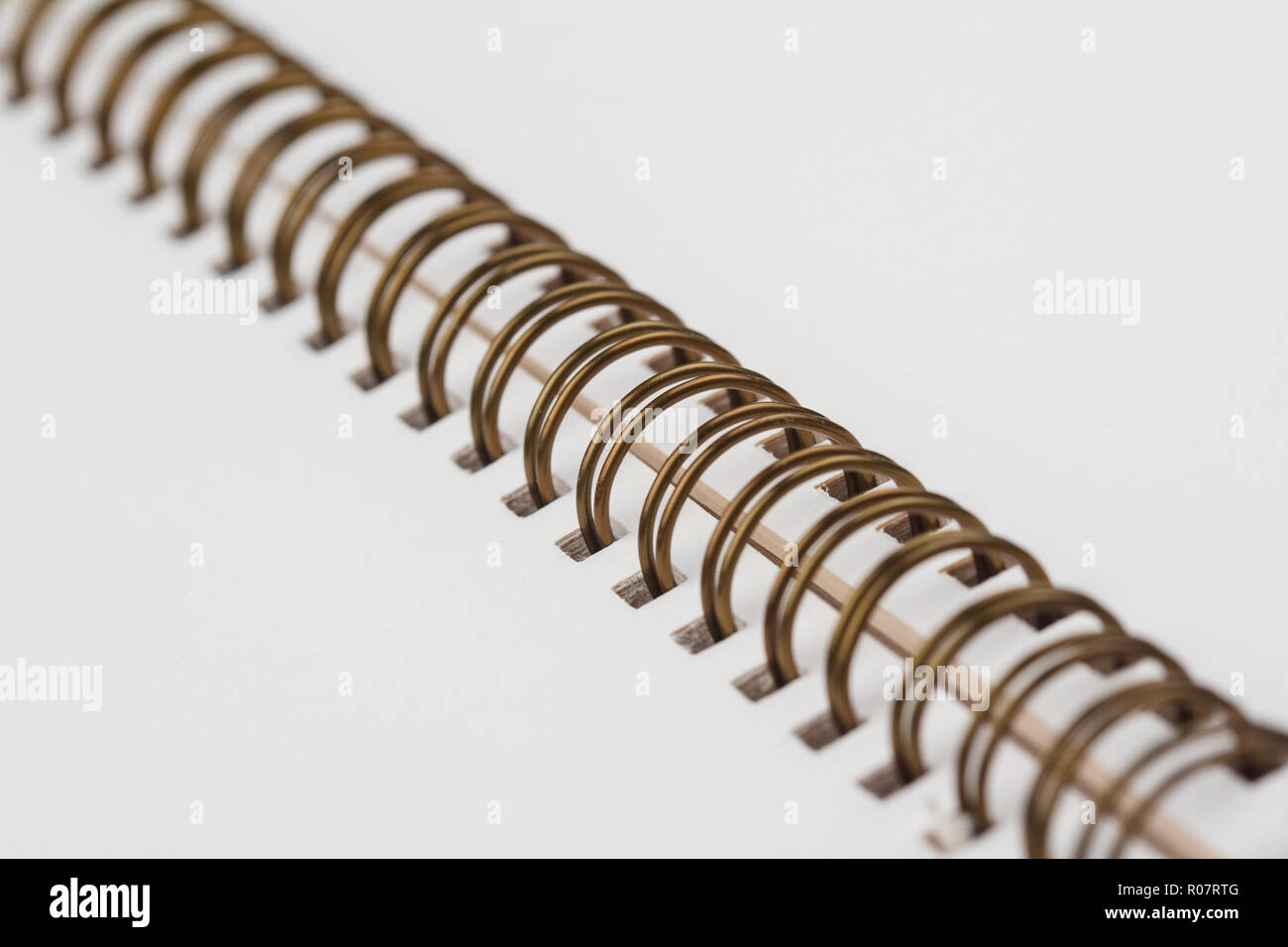 Vista prospettica laterale closeup di aprire il notebook con il rame metallico spirali e vuota Pagine bianche Foto Stock