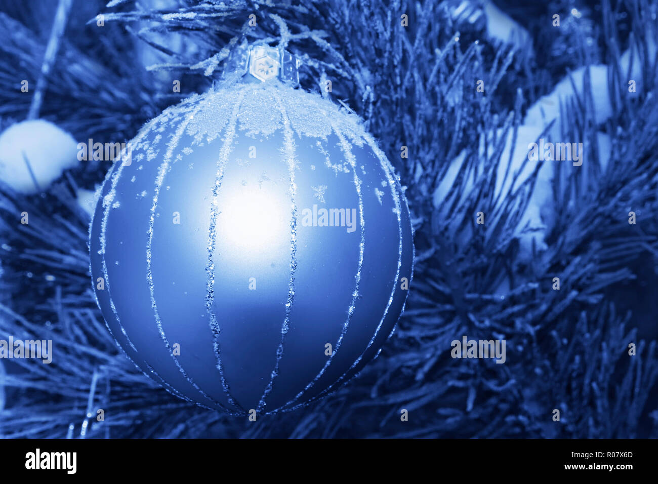 Decorazione di Natale appeso a un albero di pino all'esterno. Elaborati in tinta blu o cyanotype Foto Stock