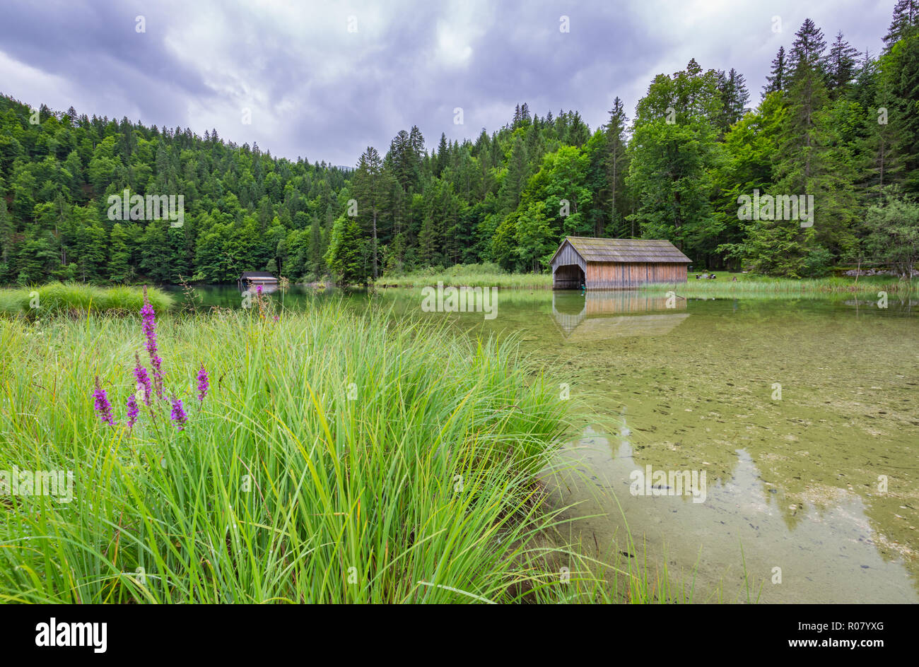 Capanno sul Lago di Braies nelle Dolomiti e Seekofel in background, Sudtirol, Italia. Un idillico paesaggio alpino con lake house e calma acqua di lago Foto Stock