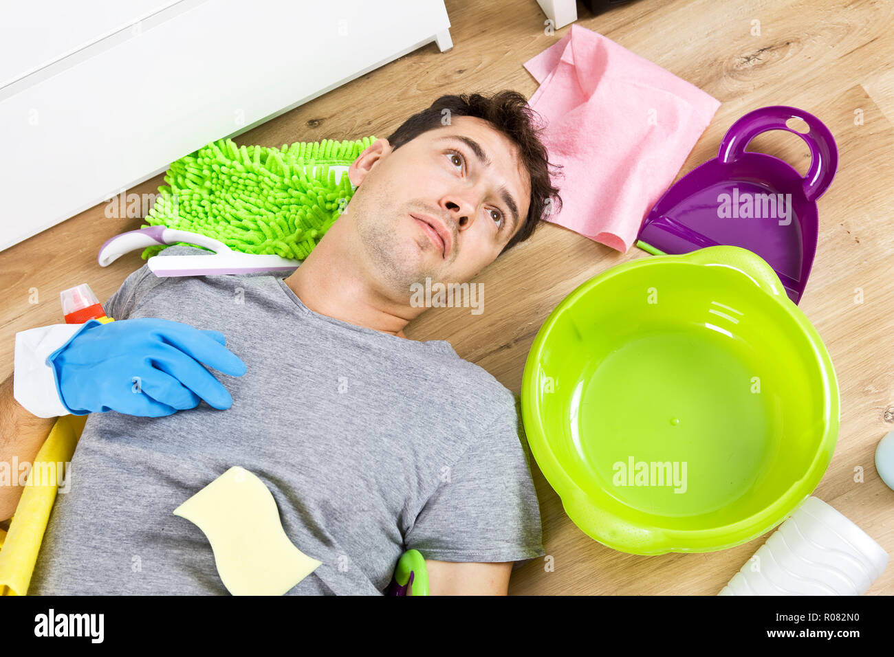 Giovane marito in crisi i lavori di casa. Close up ha sottolineato l uomo con apparecchiature per la pulizia Foto Stock