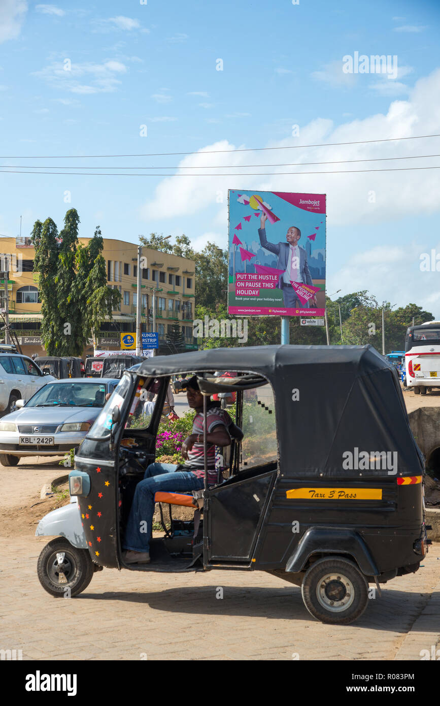 Un enorme cartellone a Mombasa con un tuk tuk Kenya Foto Stock