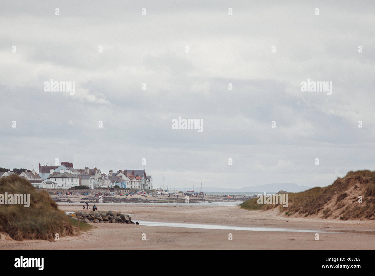 Vista di Rhosneigr da attraverso le dune di sabbia sulla spiaggia Cymyran, Anglesey, Galles del Nord, Regno Unito Foto Stock