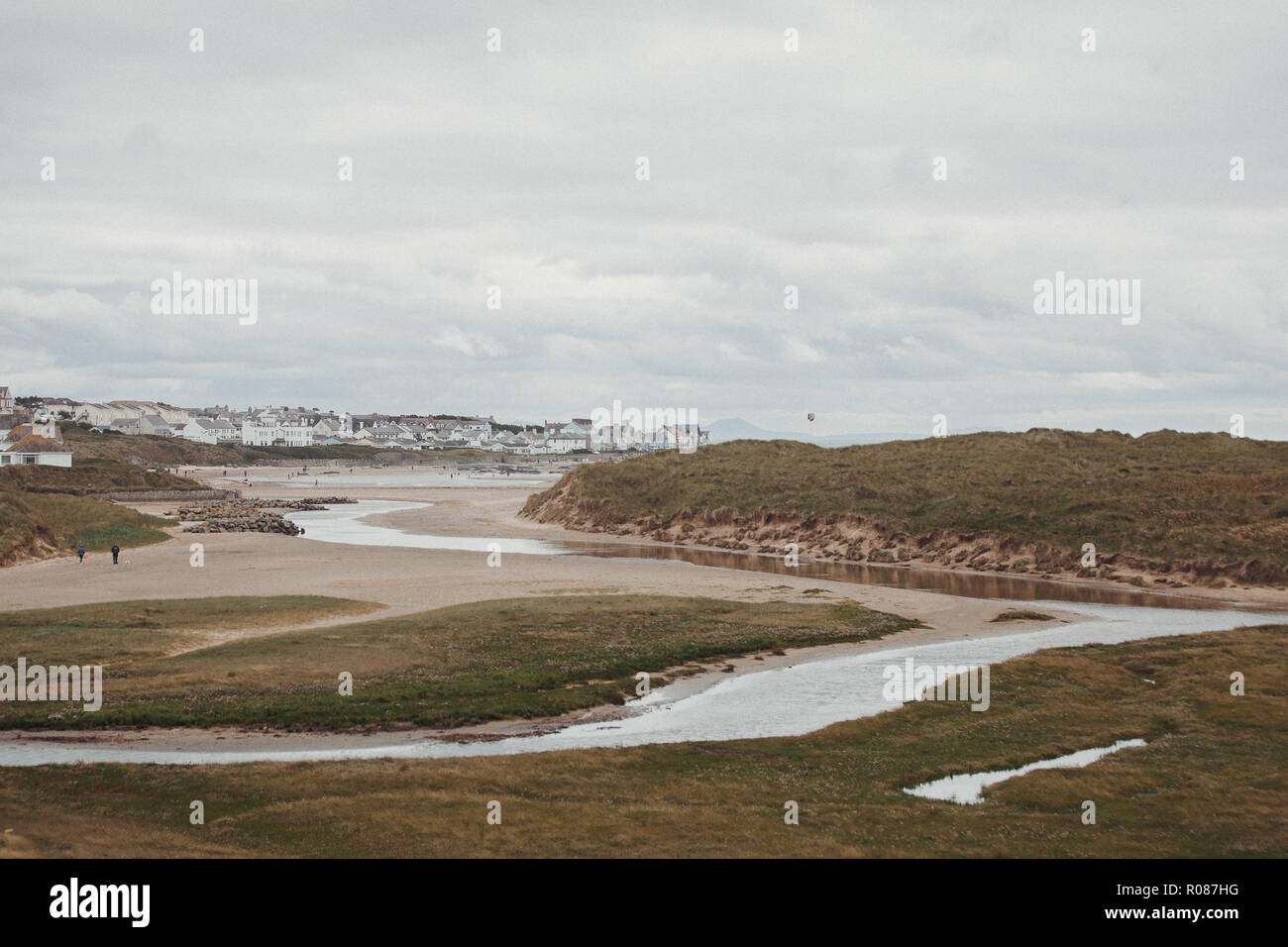 Vista di Rhosneigr da attraverso le dune di sabbia sulla spiaggia Cymyran, Anglesey, Galles del Nord, Regno Unito Foto Stock