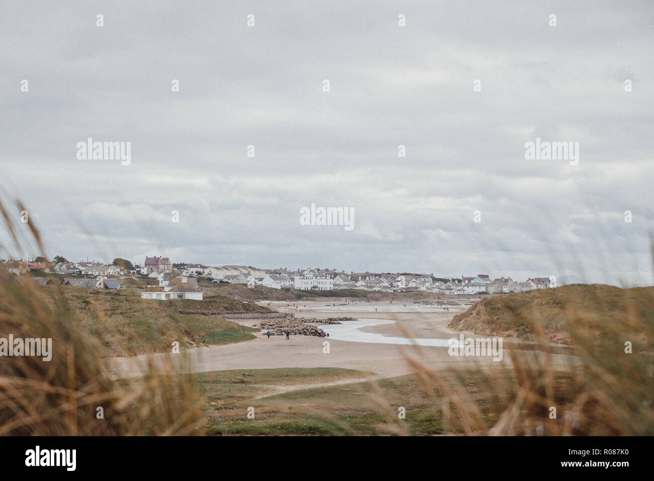 Vista di Rhosneigr da attraverso le dune di sabbia sulla spiaggia Cymyran, Anglesey, Galles del Nord, Regno Unito Foto Stock