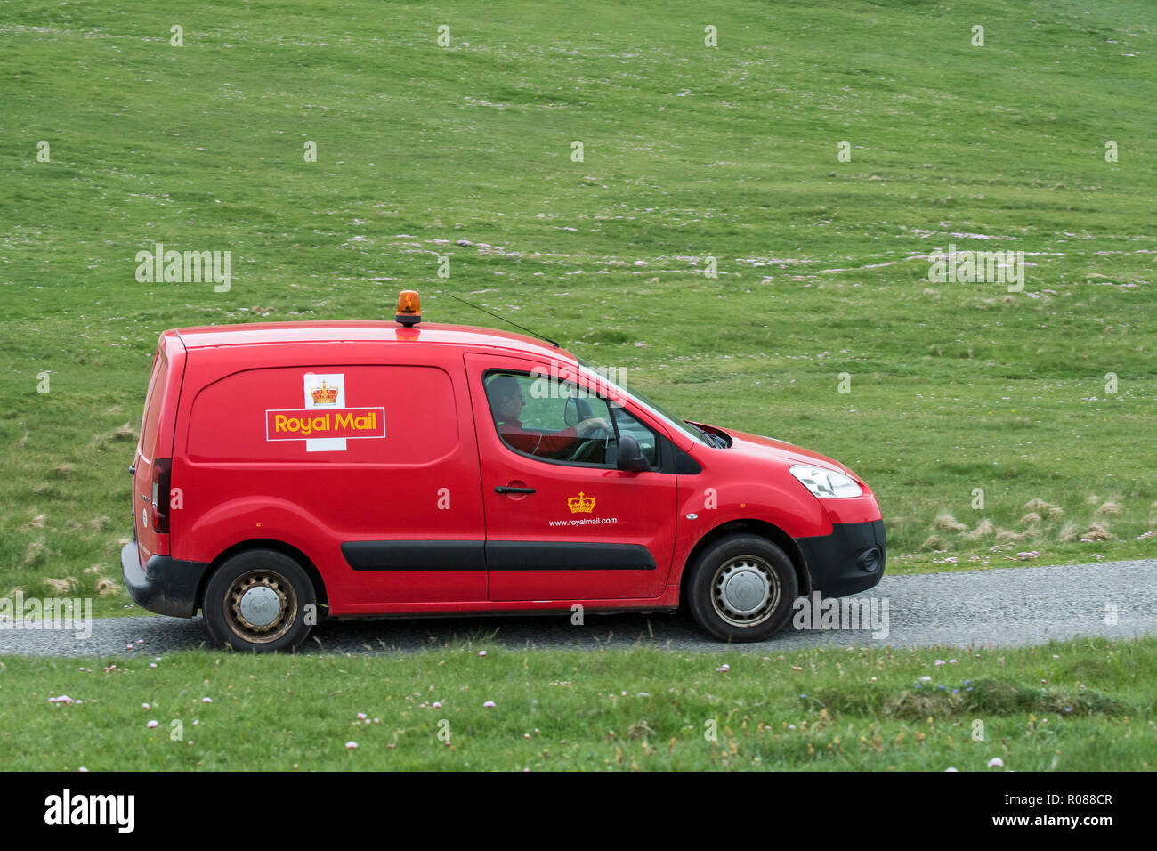 Portalettere la guida red Partner Peugeot Royal Mail post van lungo la strada desolata in Shetland, Scotland, Regno Unito Foto Stock