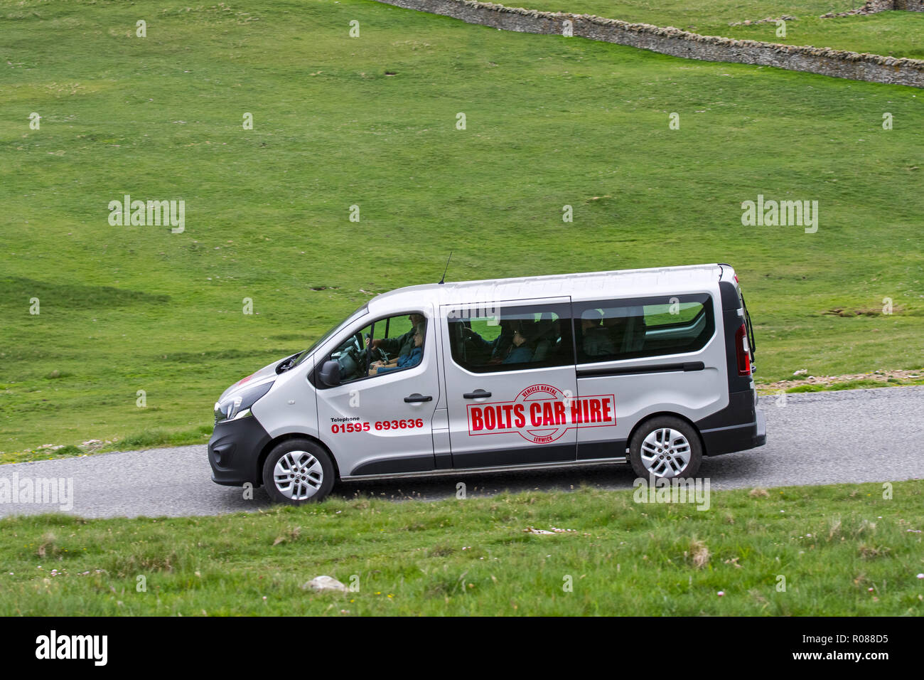 Gruppo di turisti la guida lungo la strada desolata in furgone affittato / ingaggiato van dai bulloni società di noleggio auto in isole Shetland, Scotland, Regno Unito Foto Stock