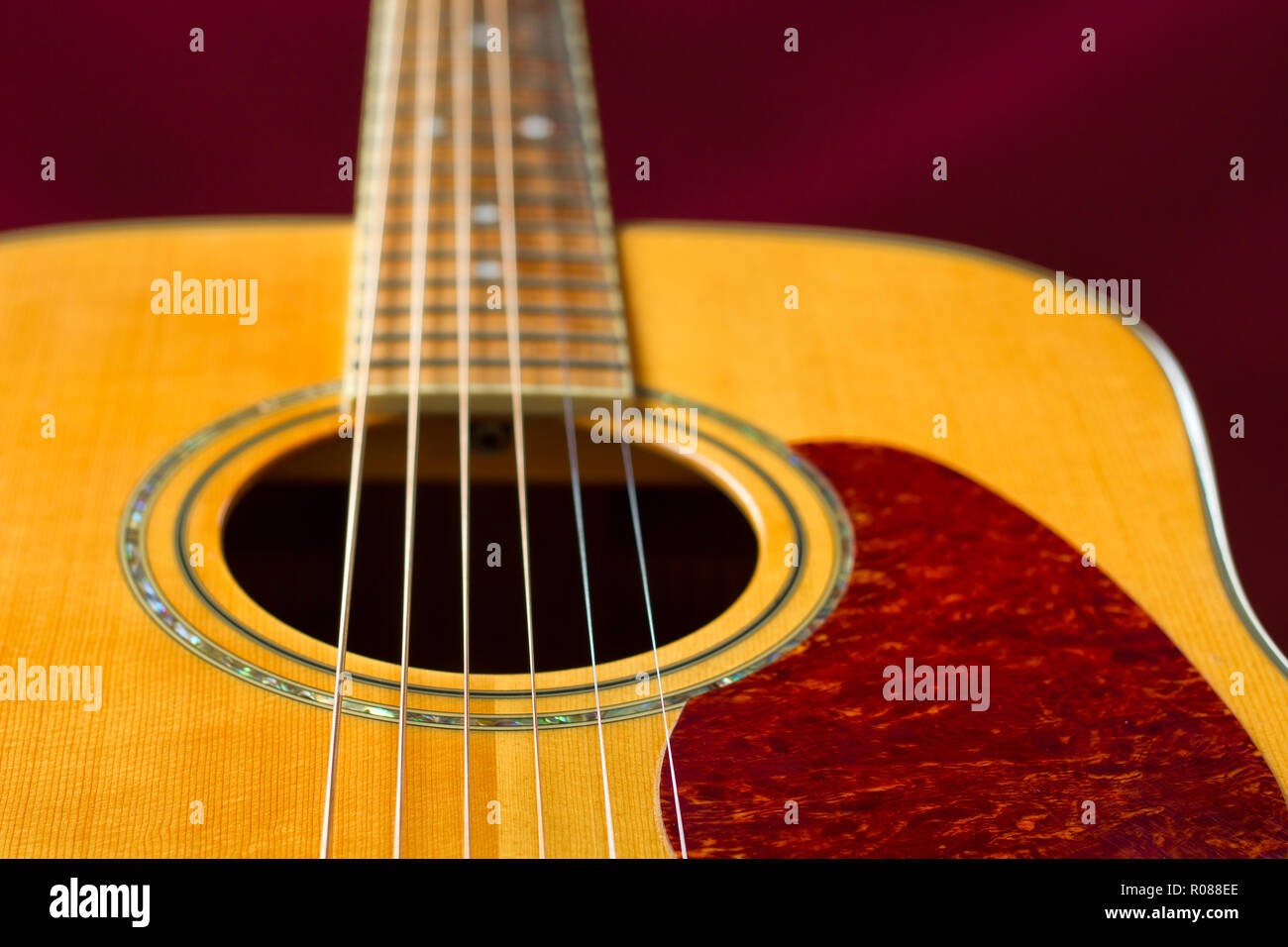 Colore ricco in solido abete top chitarra acustica dettaglio. Messa a fuoco selettiva su stringhe. Foto Stock