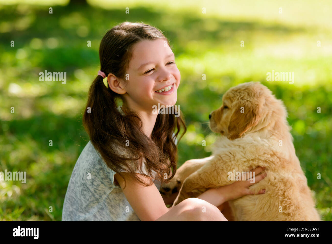 Kid e il cucciolo su verde Foto Stock