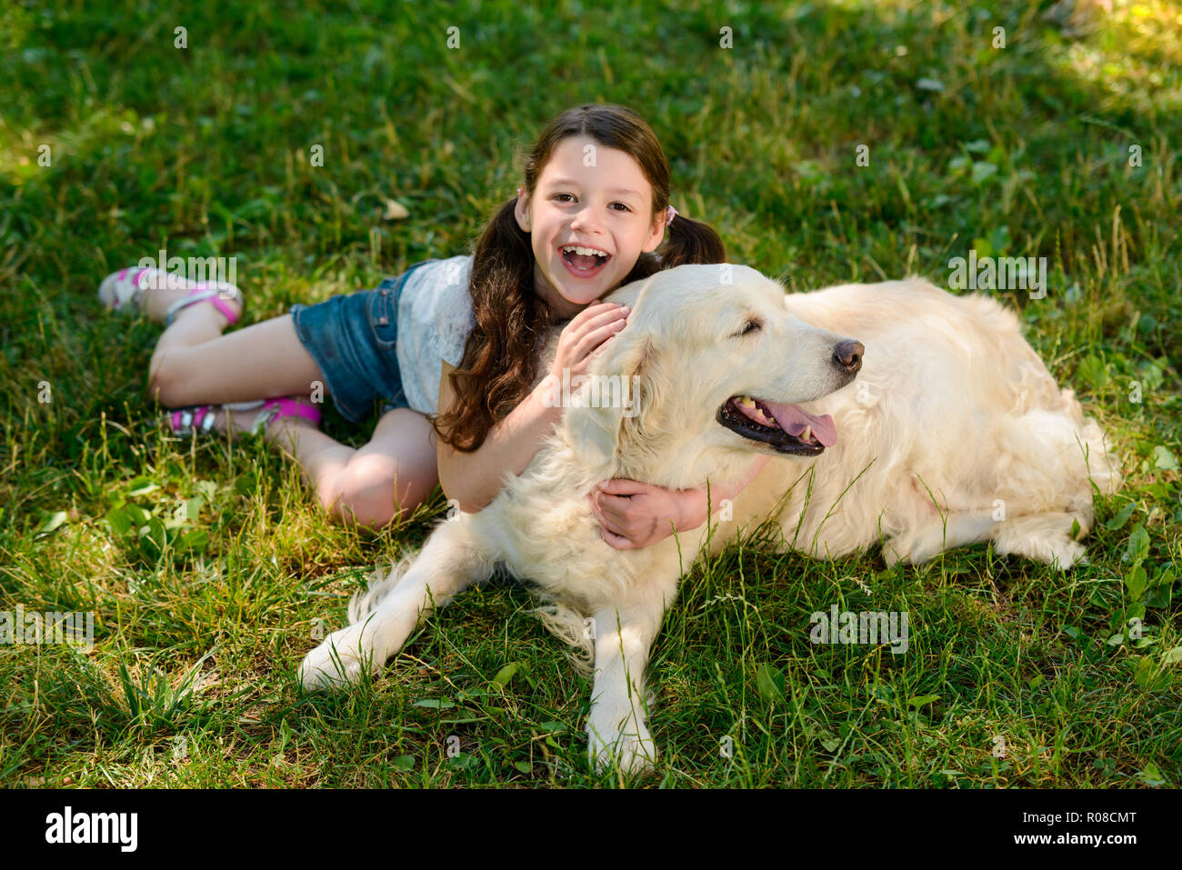 Gioiosa ragazza e il suo cane Foto Stock