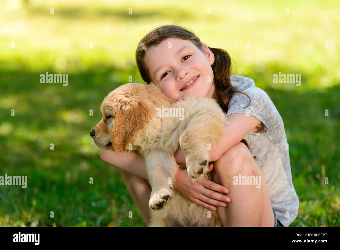 Ragazza e cucciolo su verde Foto Stock