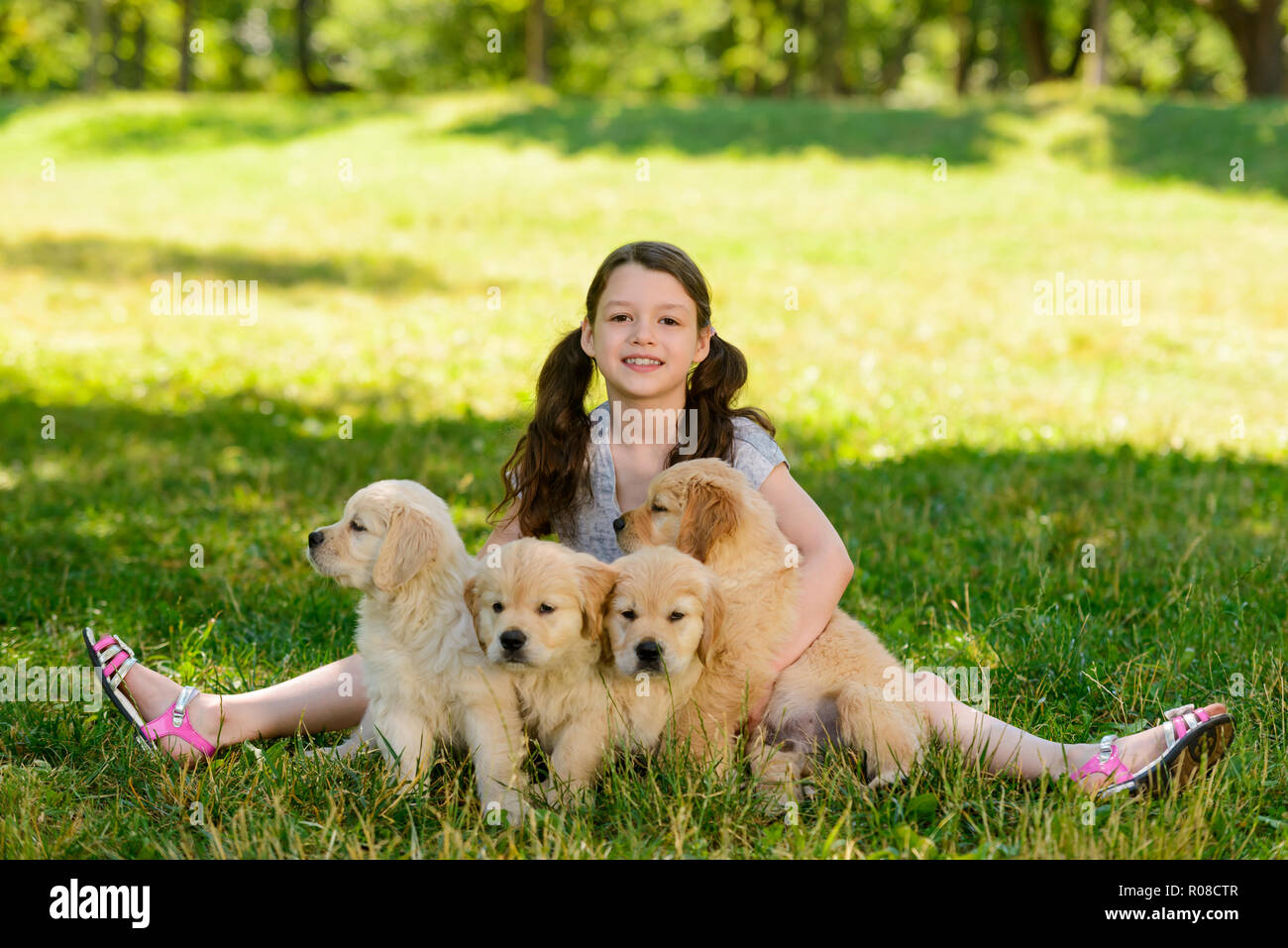 Felice ragazza e quattro cuccioli Foto Stock