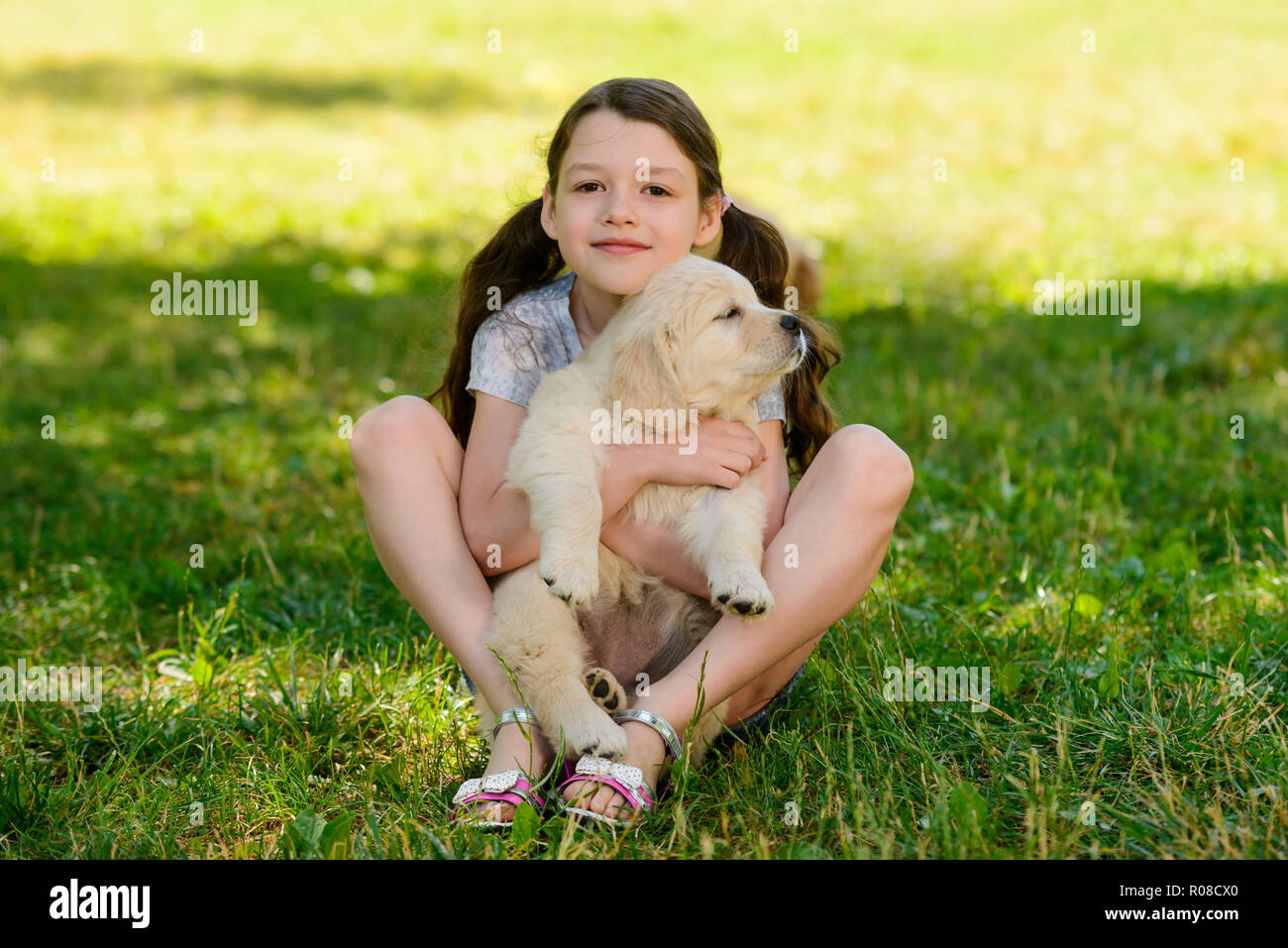 Ragazza è abbracciando un cucciolo Foto Stock