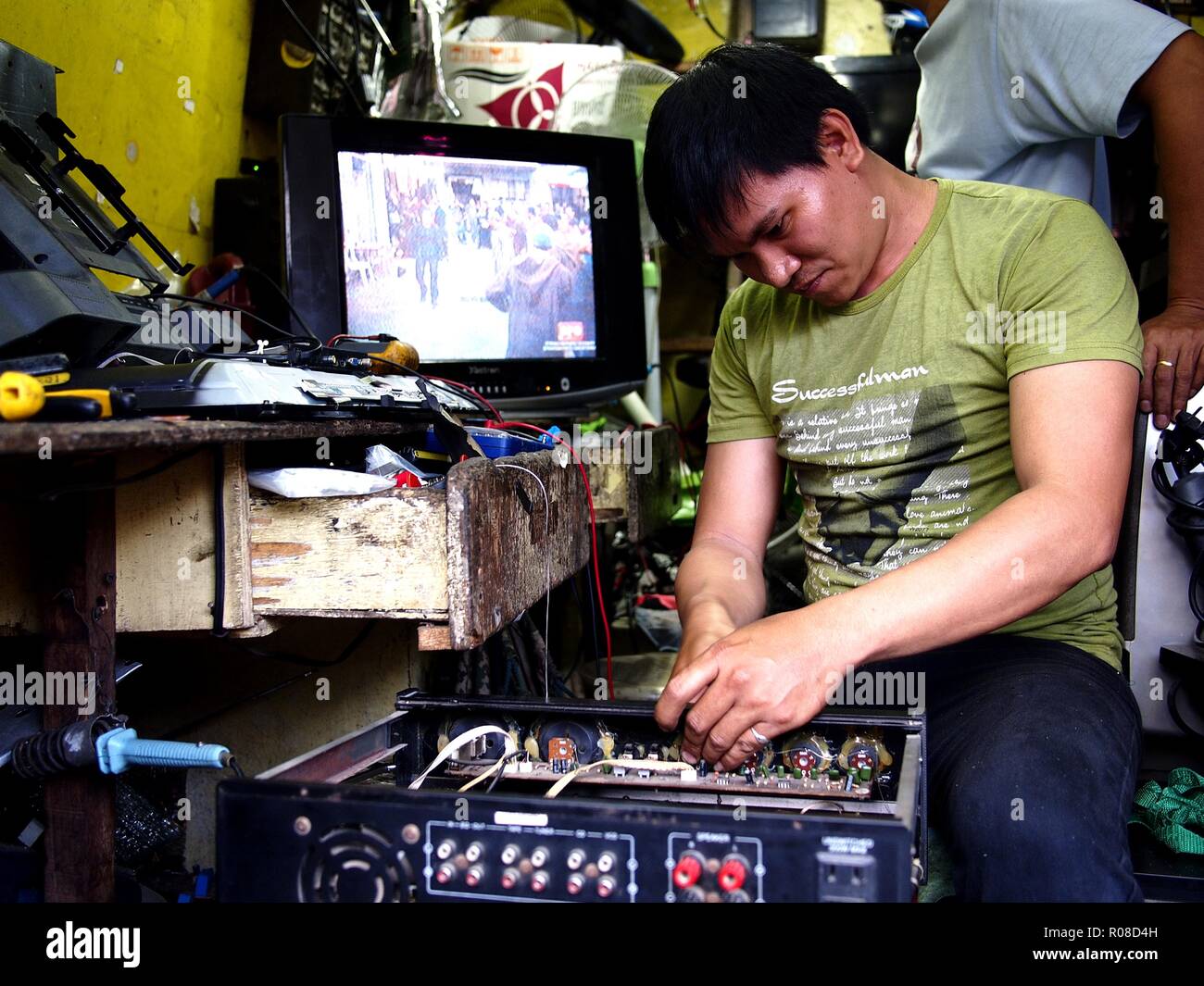 ANTIPOLO City, Filippine - 27 ottobre 2018: un uomo di riparazione risolve un elettronico oggetto domestico presso il suo negozio di riparazione. Foto Stock