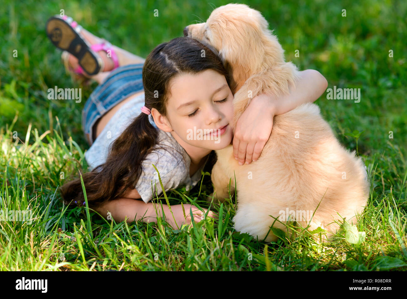 Ragazza carina abbraccia il suo cane Foto Stock