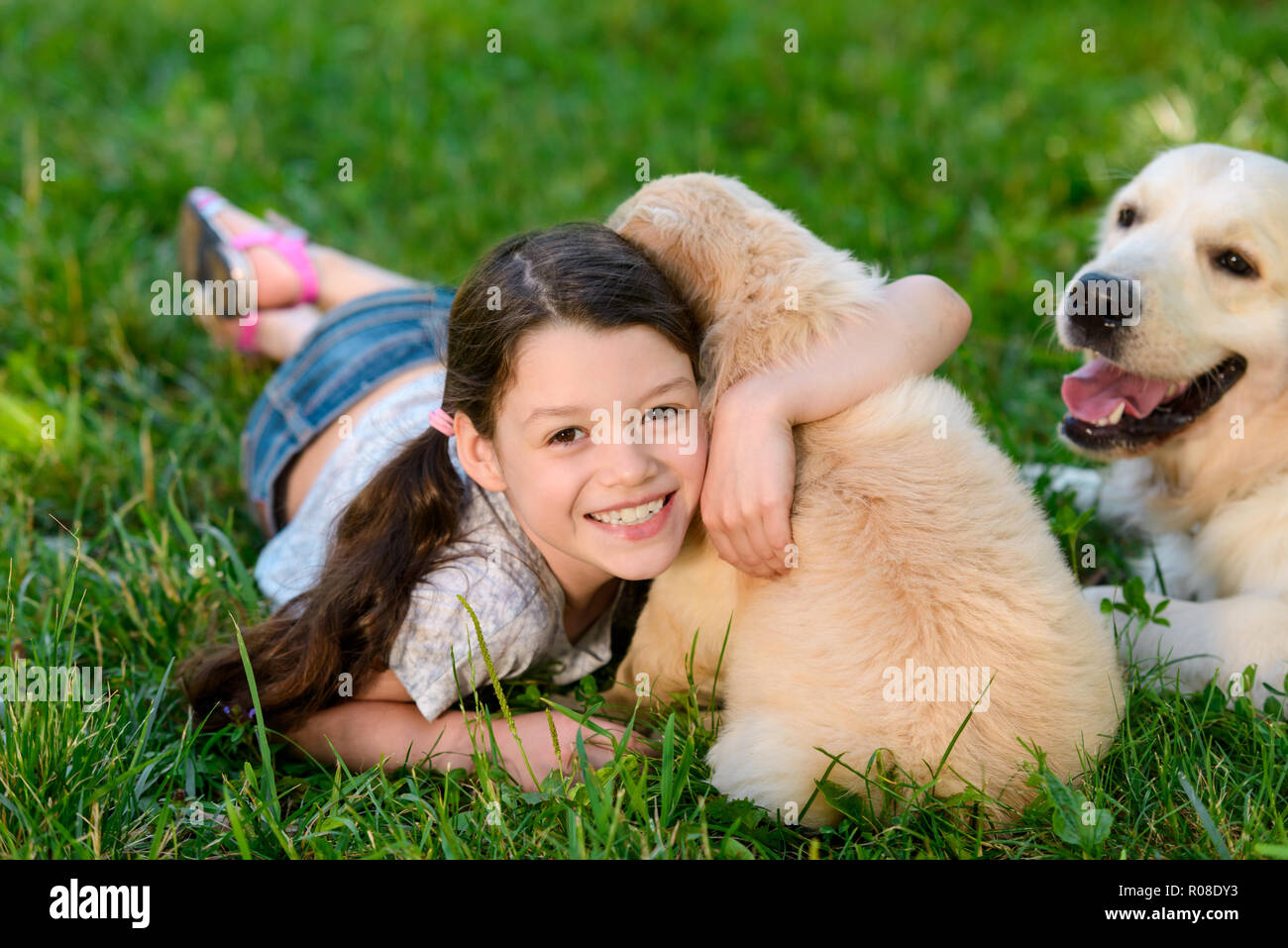 Sorridente bambino abbraccia un cucciolo Foto Stock