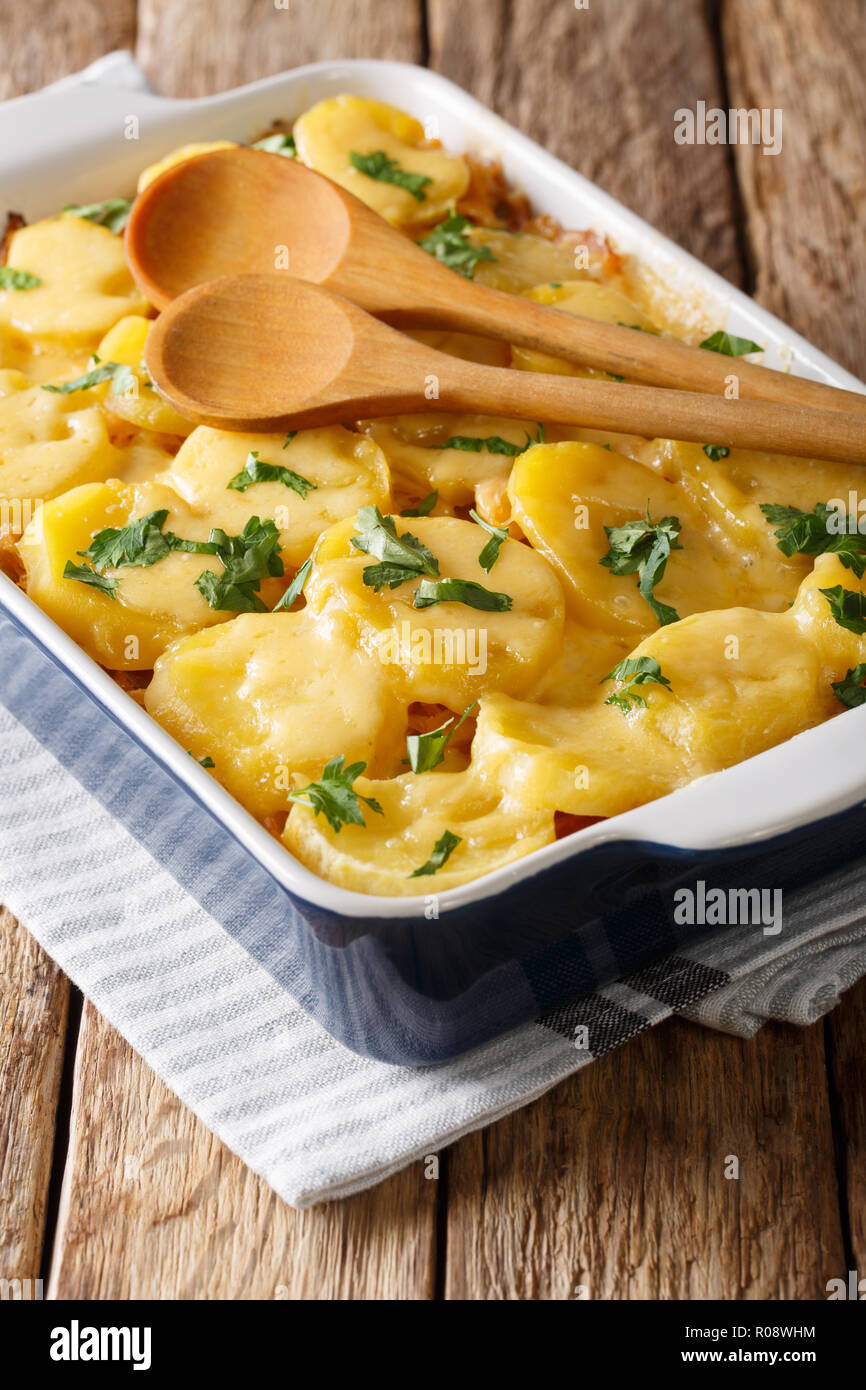 Deliziosi casseruola di crauti con patate, pancetta e formaggio close-up in una teglia sul piano verticale. Foto Stock