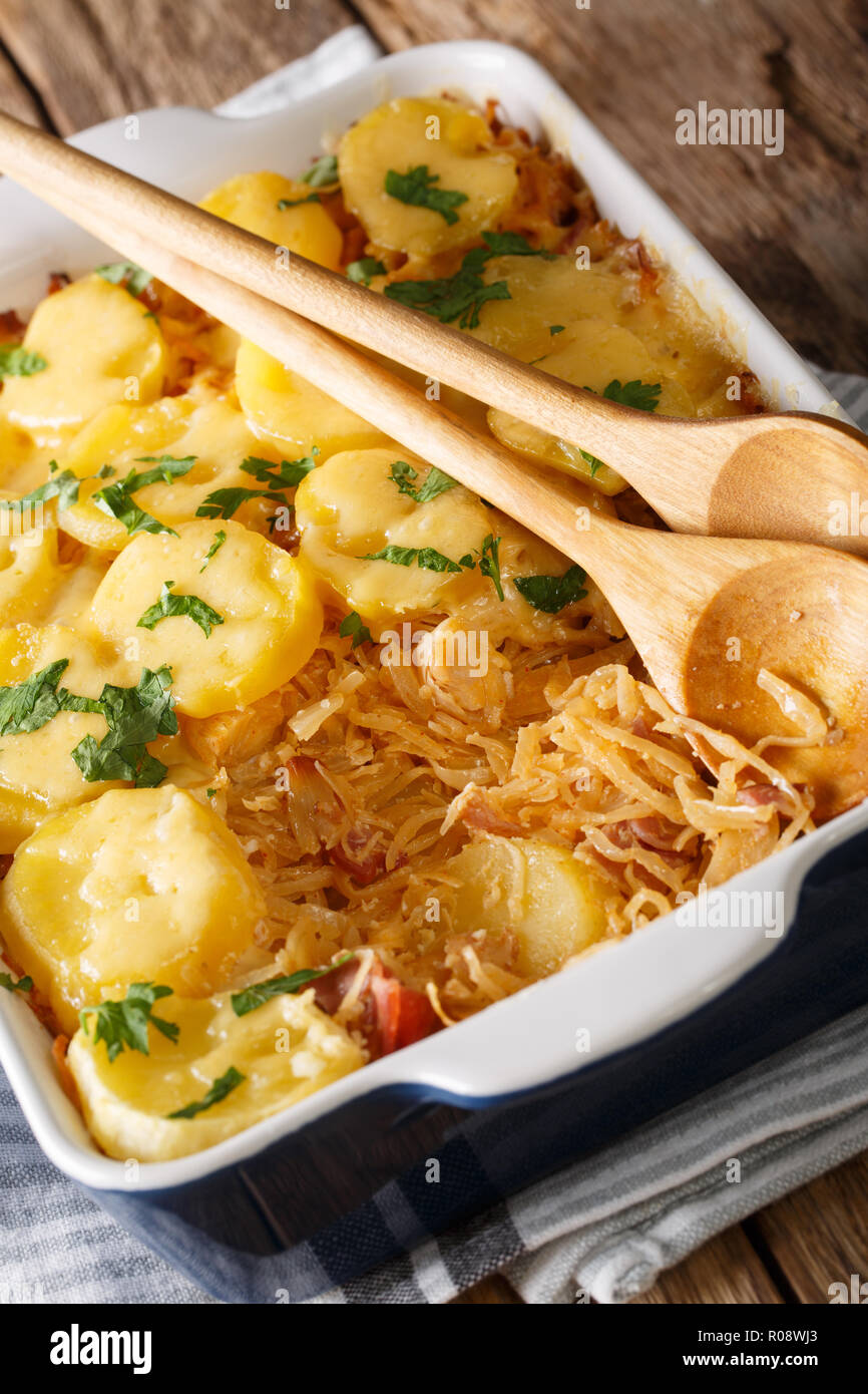 Crauti bavarese casseruola con patate, pancetta e formaggio close-up in una teglia sul piano verticale. Foto Stock