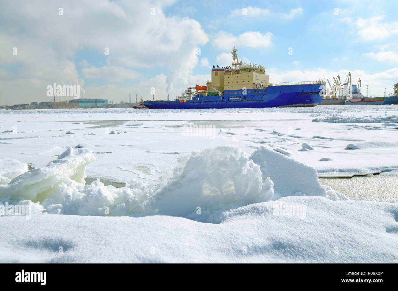 La zona di acqua del porto è coperto con ghiaccio.su il sole sta iniziando a fondere.All'orizzonte floating icebreaker. Foto Stock