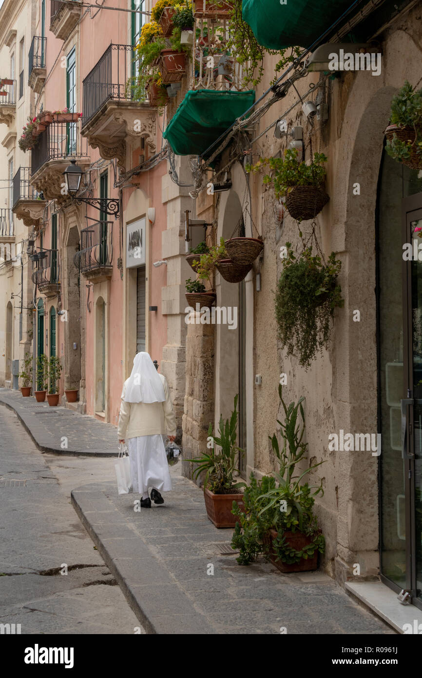 Una suora camminando giù per una strada in provincia di Siracusa Foto Stock