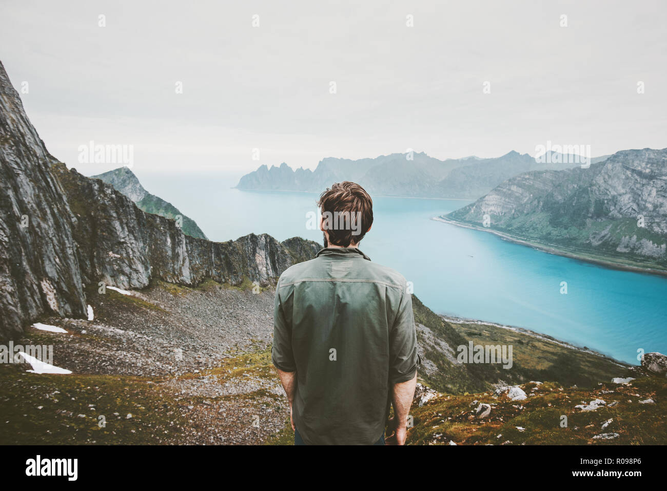 L'uomo avventuriero ammirando fjord e vista montagne Travel lifestyle adventure concept vacanze outdoor in Norvegia la solitudine pacate emozioni Foto Stock
