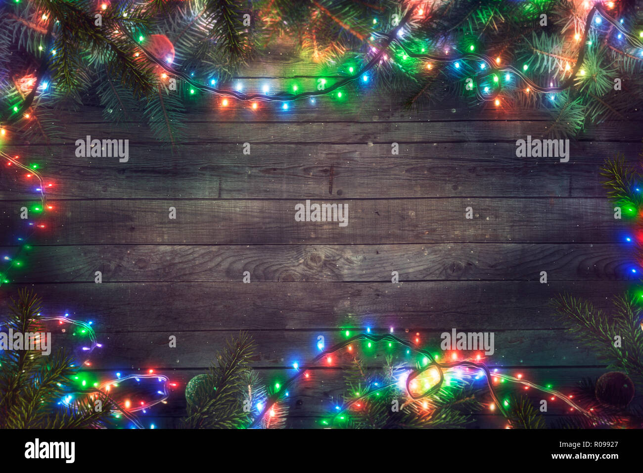 Favola di Natale Luci su legno. Sfondo di natale con luci di stringa e pino. Rami di abete Foto Stock