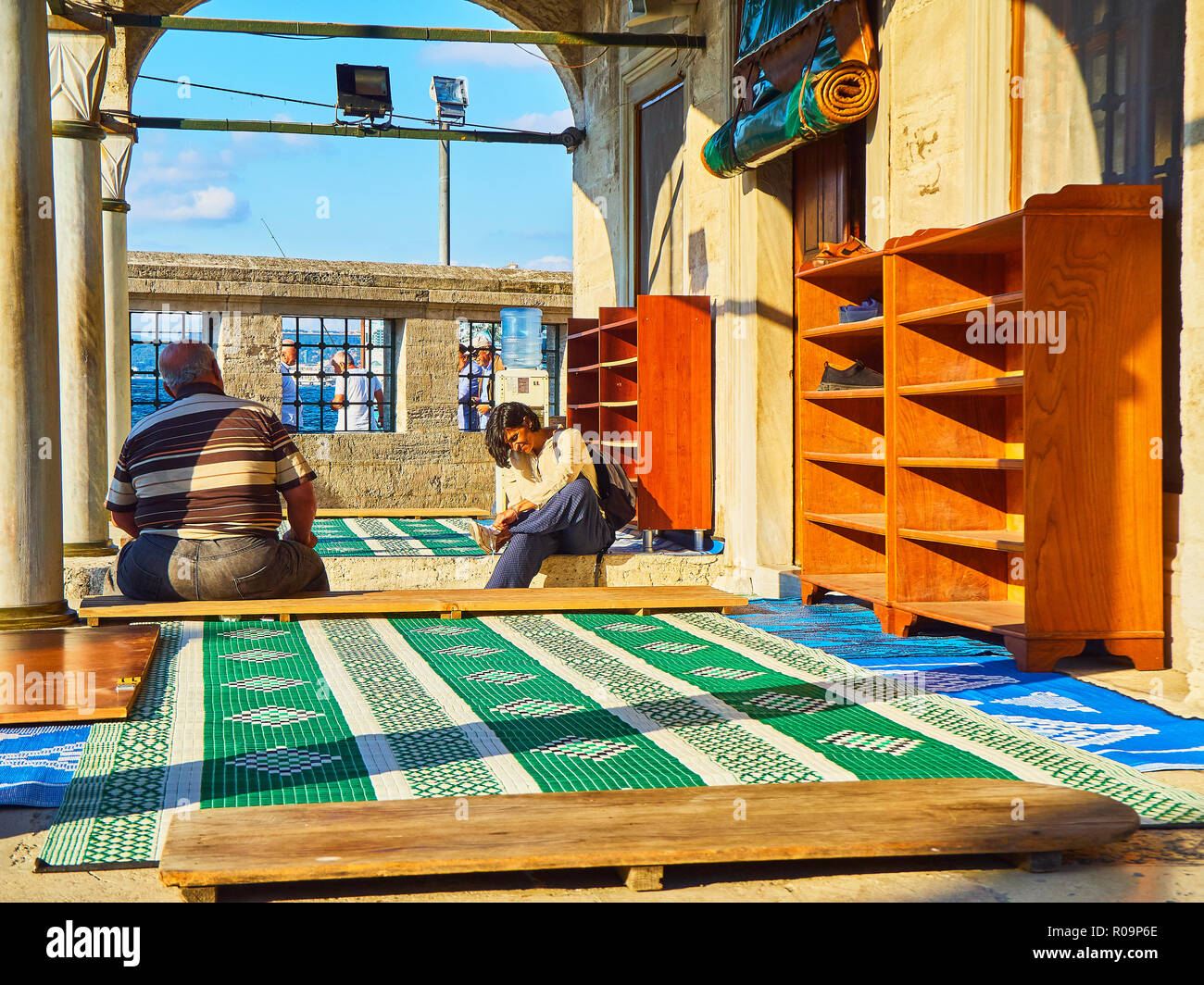 Un musulmano di decollare le sue scarpe all'ingresso del Semsi Pasa Camii moschea. Uskudar district, Istanbul, Turchia. Foto Stock