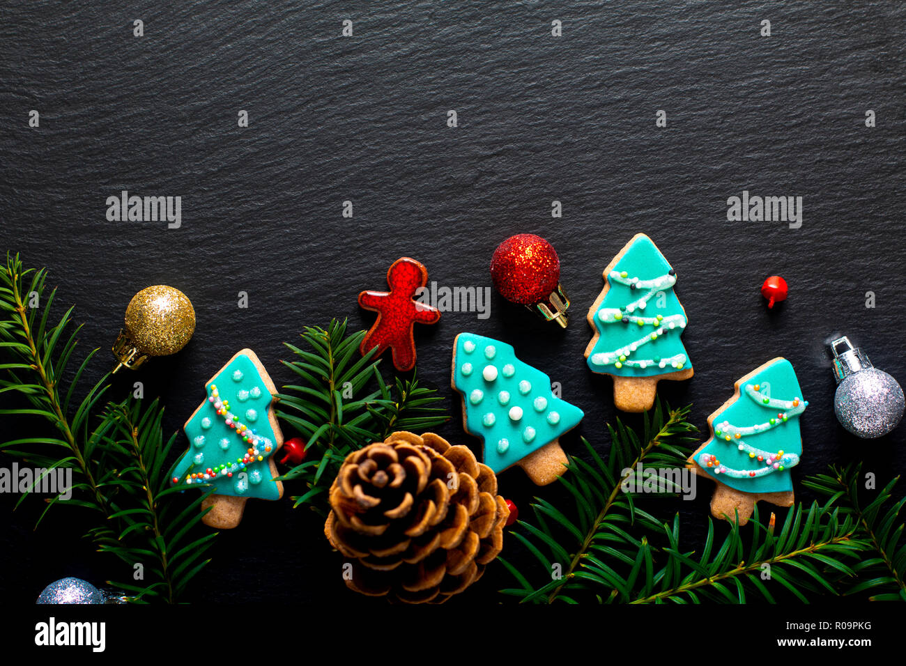 Sfondo per vacanza alimentare pastello DIY biscotti di Natale albero in ardesia nera con scheda spazio di copia Foto Stock