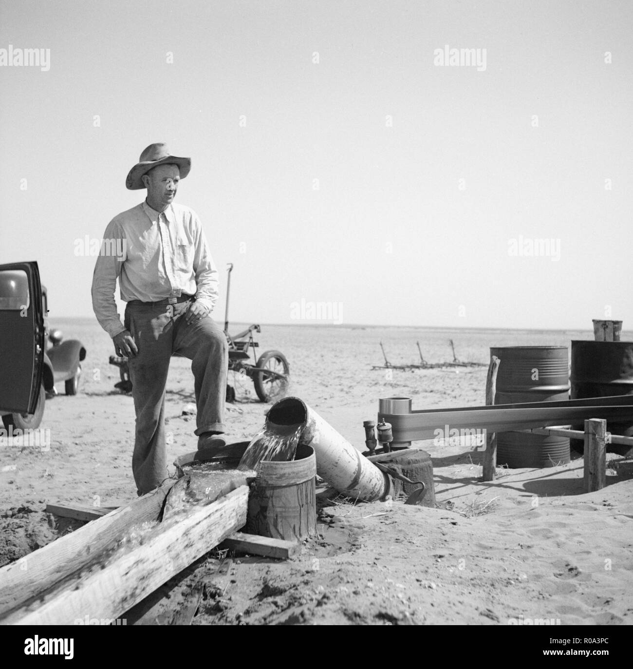 Agricoltore il pompaggio di acqua dal pozzo al riarsa campi durante la siccità, Cimarron County, Oklahoma, Stati Uniti d'America, Arthur Rothstein, Farm Security Administration, Aprile 1936 Foto Stock