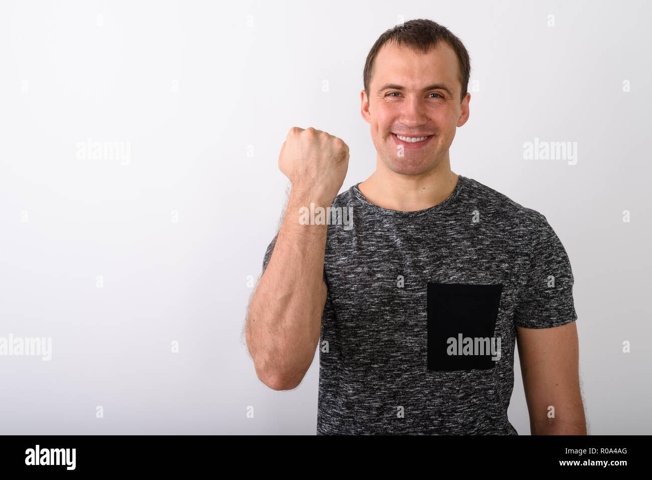 Studio shot di giovani felici muscolare di uomo sorridente mentre cercano mo Foto Stock