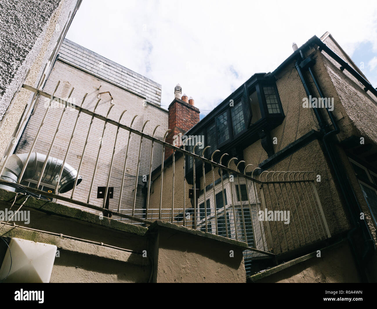 Il condotto dell'aria e la parte superiore di un edificio con un misto di stili. Il camino, windows. Oxford. Diversi tipi di muratura. Roof-top Foto Stock