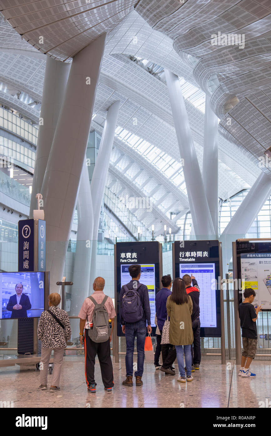 Persone che guardano gli orari in High Speed Rail Station, West Kowloon, Kowloon, Hong Kong Foto Stock