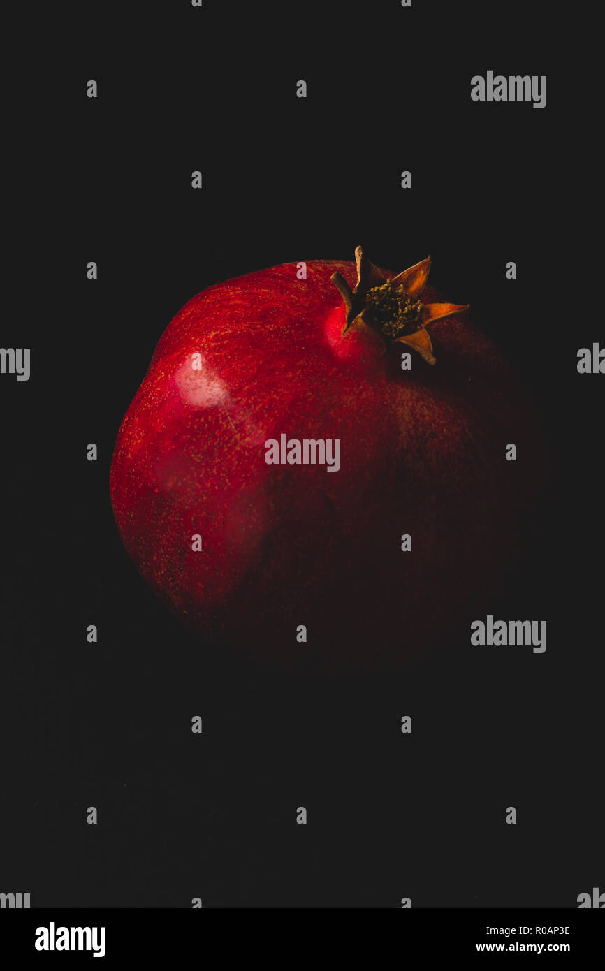 Frischer Granatapfel auf dunklem Untergrund und Hintergrund Foto Stock