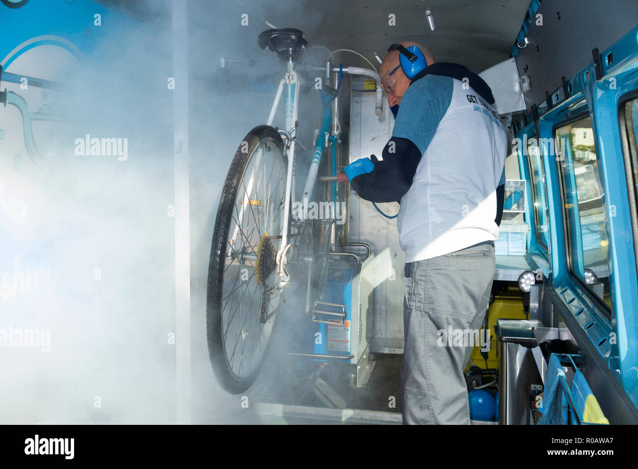 Una bici / Bici / / ciclo bi ciclo essendo pulito sotto pressione ad una unità mobile / lavaggio / dipendente di lavare la mia bike.com all'interno del retro del furgone mobile. England Regno Unito. (103) Foto Stock