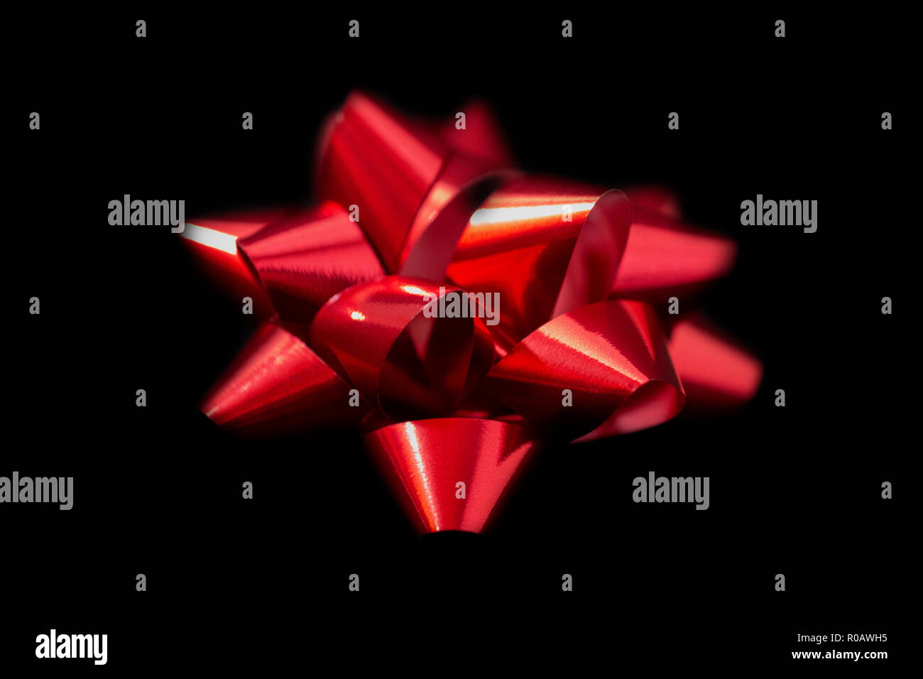 Un (1) Natale in Satin Ribbon - Satin di colore rosso su sfondo nero. Camera per copia. Foto Stock