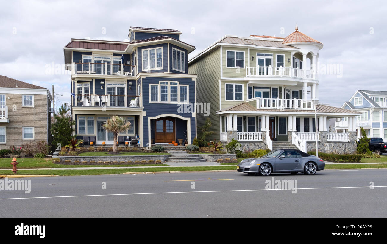 Due grandi case dall'aspetto impressionante situate su Ocean Avenue, Belamr, NJ, USA. Una Porsche Carrera sta guidando lungo davanti alle case Foto Stock