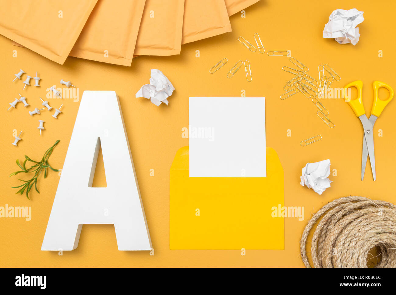 Luminose e gioiose post office lay piatto. Snail mail. Buste, forbici, fermagli, perni e la lettera A. Foto Stock