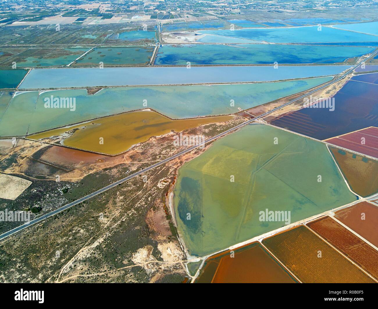 Panorama dell'antenna birds eye view autostrade e la Riserva Naturale di Santa Pola i laghi di sale. Drone photo per la produzione di sale area paludosa vista da sopra. Torrevie Foto Stock