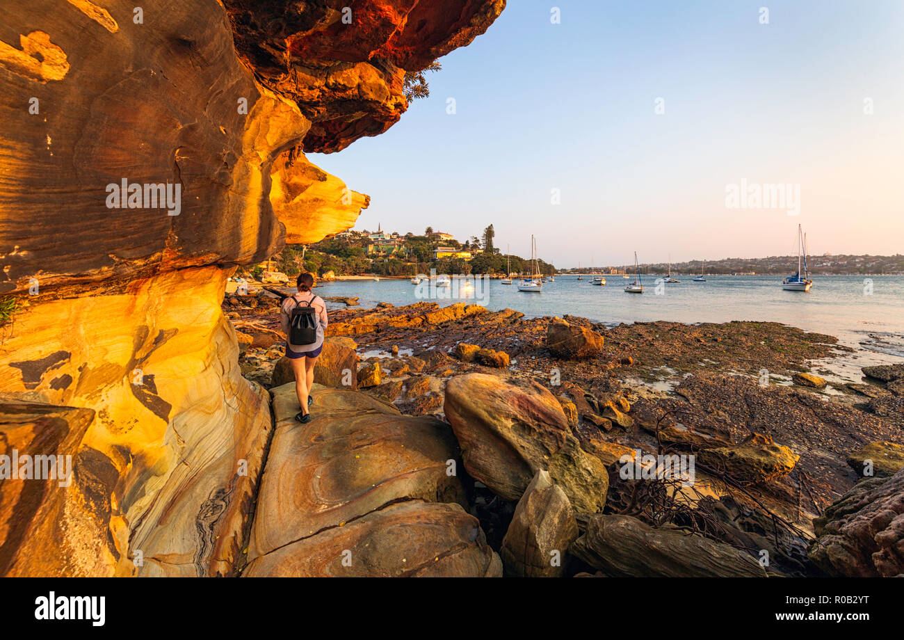 Una donna che cammina lungo il Romitorio Foreshore via alla Baia di Eremita nella Vaucluse. Sydney, Australia Foto Stock