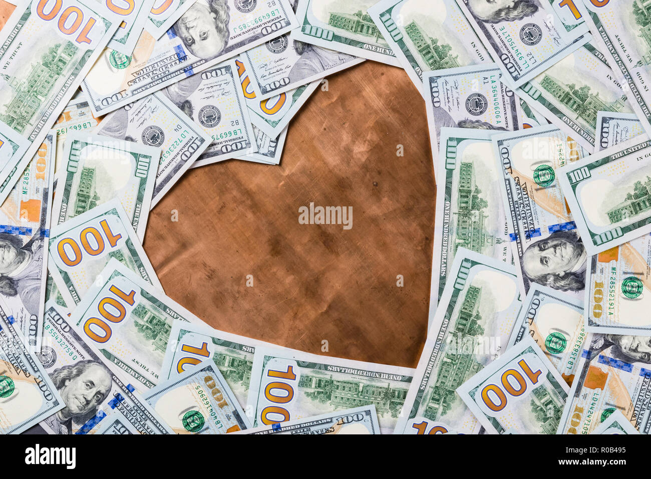 Bronzo rame forma di cuore nel centro del dollaro sullo sfondo di denaro Foto Stock